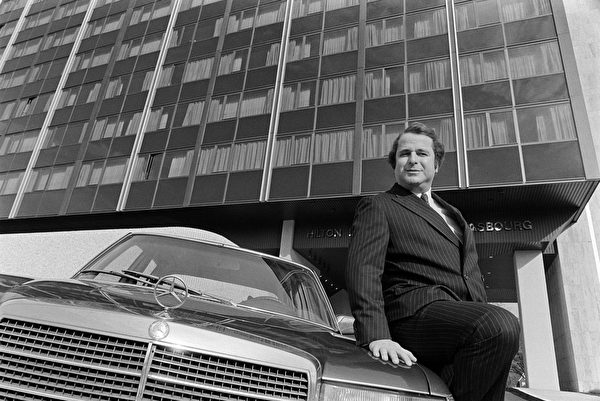 宾士汽车很久以来被认为是身份的象征。图为法国作家Paul-Loup Sulitzer坐在宾士汽车上留影。(MARCEL MOCHET/AFP/Getty Images)
