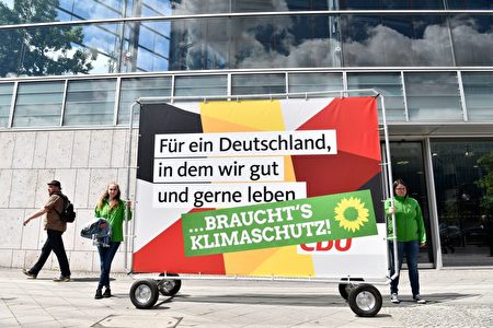 绿党的这个海报改写了基民盟的竞选口号。基民盟说要“打造一个我们希望生活的德国”，绿党接上一句话,那么“需要气候保护”，旁边还附上一个标志性的向日葵。( JOHN MACDOUGALL/AFP/Getty Images)