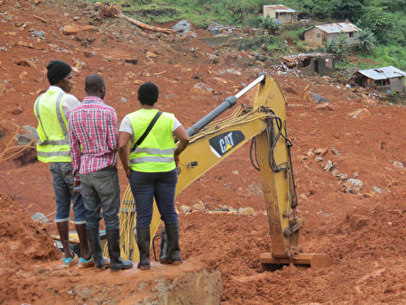 塞拉利昂首都發生嚴重的泥石流，救援人員在災難現場仔細搜尋是否有生還者。（AIDU BAH / AFP / Getty Images）
