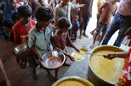 Indian villagers queue for food at the flood-hit Dagrua village in Bihar state on August 19, 2017. Nearly 600 people have died and millions have been affected by monsoon floods in South Asia, officials said Saturday, as relief and rescue operations continued. / AFP PHOTO / DIPTENDU DUTTA (Photo credit should read DIPTENDU DUTTA/AFP/Getty Images)