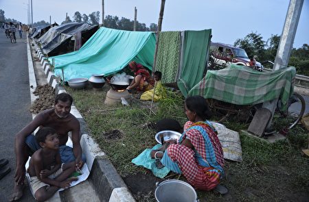 Indian flood effected villagers cooks food in temporary shelters along National Highway 34 as their houses were submerged by flood waters in Gazole village at Malda district in the Indian state of West Bengal on August 22, 2017. More than 24 million people have been affected by some of the worst flooding to hit South Asia in decades, with large areas of land submerged in water. Authorities in Bangladesh, India and Nepal have put the death toll at more than 750 since August 10, when a series of deluges began spreading with the annual monsoon season. / AFP PHOTO / DIPTENDU DUTTA (Photo credit should read DIPTENDU DUTTA/AFP/Getty Images)