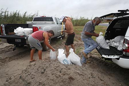 CORPUS CHRISTI, TX - AUGUST 25: Cody Munds, Lee Martin and John Pezzi (L-R) fill sandbags as people prepare for approaching Hurricane Harvey on August 25, 2017 in Corpus Christi, Texas. Hurricane Harvey has intensified into a hurricane and is aiming for the Texas coast with the potential for up to 3 feet of rain and 125 mph winds. (Photo by Joe Raedle/Getty Images)