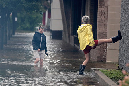 GALVESTON, TX - AUGUST 26: Residents walk along a street flooded by rain from Hurricane Harvey on August 26, 2017 in Galveston, Texas. Harvey, which made landfall north of Corpus Christi late last night, is expected to dump upwards to 40 inches of rain in Texas over the next couple of days. (Photo by Scott Olson/Getty Images)