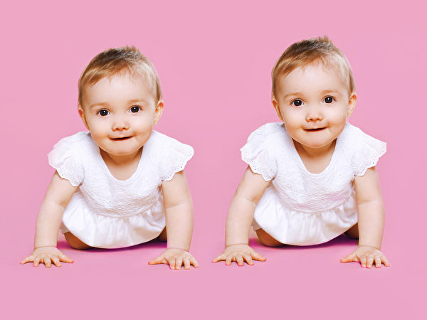 Portrait of two sweet twins baby crawls together。（fotolia）
