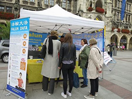 二零一七年九月二日，法輪功學員在德國慕尼黑的瑪琳廣場（Marienplatz）舉辦講真相活動，不少過往民眾駐足了解真相，並簽名譴責中共活摘法輪功學員器官。（明慧網） 
