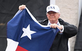 8月29日总统川普在德克萨斯州手持州旗为民众加油。 (JIM WATSON/AFP/Getty Images)