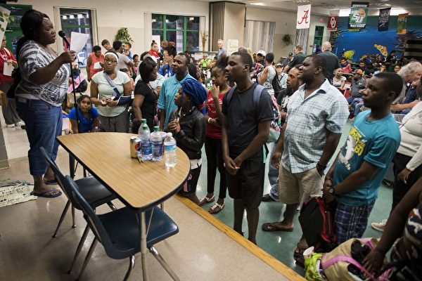 9月9日在佛羅里達州坦帕作為庇護所的一所小學裡，坦帕居民等待分發食物。 艾瑪颶風以最大強度5級颶風在古巴登陸後，9月9日略微減弱到4級風暴。（AFP PHOTO / JIM WATSON）