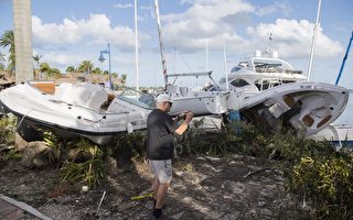 一名男子在9月11日在佛羅里達州邁阿密的一個碼頭拍攝艾瑪颶風損害的船隻。（AFP PHOTO / SAUL LOEB）