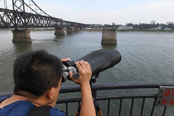  横跨鸭绿江的中朝友谊桥边有一座“断桥”，是辽宁省丹东市的著名旅游景点。站在中国丹东一侧，可以远眺朝鲜新义州。（AFP PHOTO / GREG BAKER）