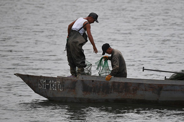 两名朝鲜男子在鸭绿江上打鱼。（GREG BAKER / AFP / Getty Images）