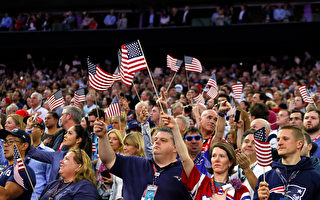川普（特朗普）9月22日严厉批评这些球员不尊重美国国旗，应被解雇。图为球迷看比赛时挥舞国旗。(Photo by Kevin C. Cox/Getty Images)