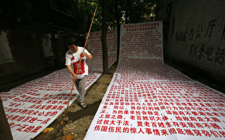中共憲法從頒布開始一直是一紙空文，無法保護公民合法權益。圖為一拆遷戶，因無法獲得合法權益，身著塗寫著「憲法」二字的衣服，討要合法利益。(Photo by China Photos/Getty Images)