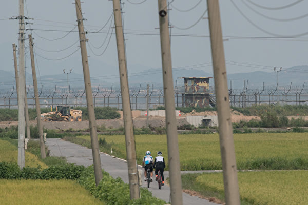 自行车骑士经过非军事区的韩国守卫。(ED JONES/AFP/Getty Images)