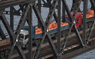 2017年9月4日，丹东的大卡车通过中朝边境大桥从朝鲜开回中国。   (GREG BAKER/AFP/Getty Images)
