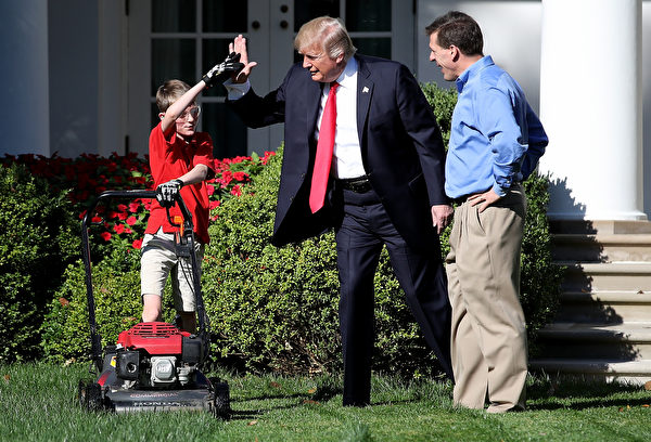  2017年9月15日上午，美国总统川普带着小弗兰克父子俩在白宫的玫瑰花园推草坪时，和他击掌相庆。(Win McNamee/Getty Images) 