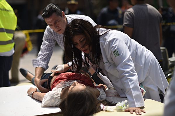 9月19日墨西哥城發生7.1級強震，造成至少上百人遇難。圖為當地救援者和志願者正在搶救傷者。(PEDRO PARDO/AFP/Getty Images)