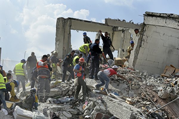 9月19日墨西哥城發生9.1級強震，造成至少上百人死亡。圖為救援者和志願者在瓦礫中尋找倖存者。 (ALFREDO ESTRELLA/AFP/Getty Images)