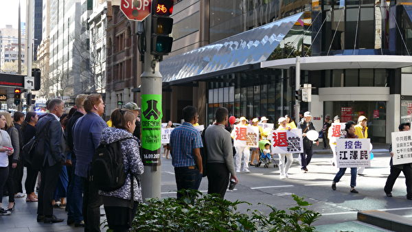 9月8日，澳洲法轮功学员的游行队伍穿过悉尼市商务中心，附近上班族驻足观看。（安平雅／大纪元）