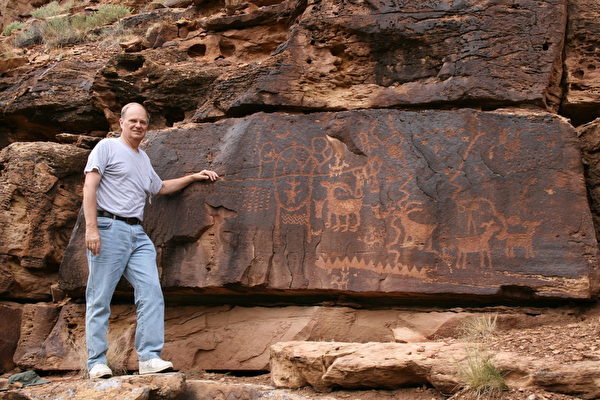 拉斯坎普在犹他州九英里峡谷的石刻文之前留影。(Courtesy of John Ruskamp)