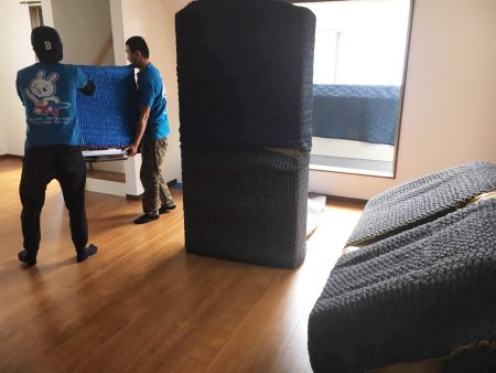 搬家公司员工帮民众打包家具搬出房屋。