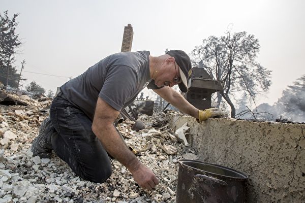 北加州发生有史以来最惨重的火灾，至少3500栋建筑物烧毁，近3000人失联。图为2017年10月10日，加州圣塔罗莎，一位民众在他被烧毁的房子中寻找留存的东西。(David McNew/Getty Images)