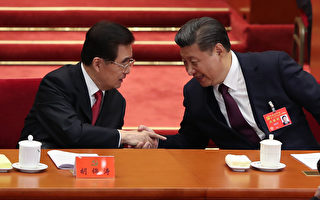 中共「十九大」18日起在北京召開。圖為習近平（右）宣讀完「十九大」報告後，回到主席台與胡錦濤（左）握手。 (Lintao Zhang/Getty Images)