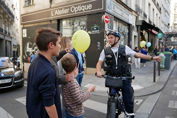 巴黎警察在给路人解释法轮功游行的目的。（张妮／大纪元）