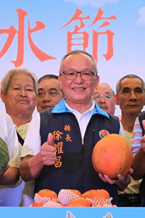  縣長徐耀昌展示南庄特大鮮甜的木瓜。（許享富／大紀元）