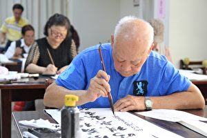 长青组最年长者为82岁的朱映明，陶醉书法逸趣。（许享富／大纪元）