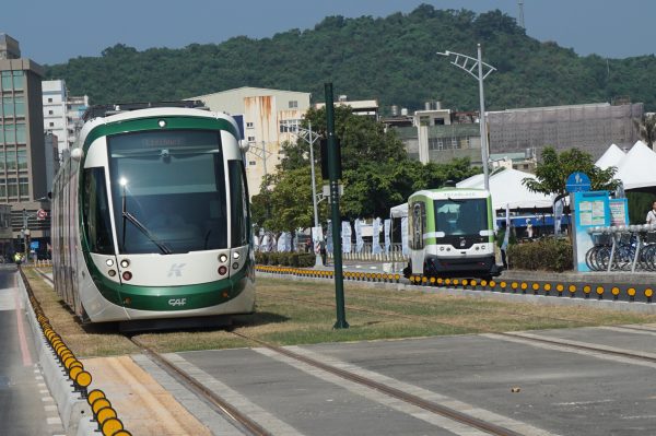 高雄推展各式绿色运具，一辆轻轨(左前)与无人驾驶小巴士（右后），恰巧在马路上交会而过。（李怡欣／大纪元）