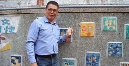 嘉義市文雅國小家長會長帝谷通信董事長江進隆左手指向自己作品。