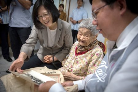 總統蔡英文（左）分享百歲人瑞謝林霞妹（中）過去照片。（總統府提供）