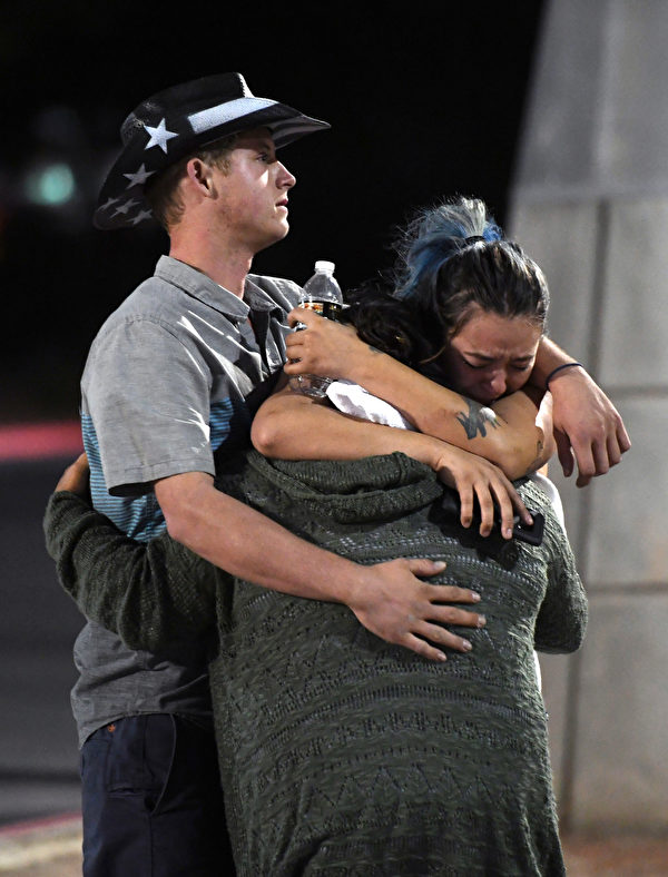在2017年10月2日，在拉斯維加斯91號收穫鄉村音樂節槍擊案發生之後，人們在Thomas＆Mack Center外面擁抱和哭泣。（Ethan Miller / Getty Images）