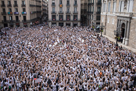 BARCELONA, SPAIN - OCTOBER 07: Thousands of people, dressed in white gather and chant the slogan "lets talk" outside the Barcelona City Hall on October 7, 2017 in Barcelona, Spain. Tension between the central government and the Catalan region have increased after last weekend's independence referendum. Spanish shares and bonds have been hit hard since the political turmoil with fears Spain could be on the brink of a financial crisis should the civil unrest continue. Two of Spain's largest banks, Banco de Sabadell and CaixaBank have both held meetings discussing steps to transfer their registered headquarters to other cities in Spain. The Spanish government suspended the Catalan parliamentary session planned for Monday in which a declaration of independence was expected to be made. (Photo by Chris McGrath/Getty Images)