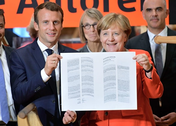 德國總理默克爾和法國總統馬克隆雙雙出席書展開幕式,展示用傳統印刷術印製的《人權宣言》。 (Thomas Lohnes/Getty Images)