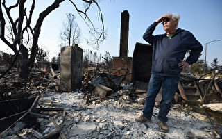 圖為10月11日在加州聖羅莎(Santa Rosa)，屋主站在房子被野火燒毀後的廢墟上。(ROBYN BECK/AFP/Getty Images)