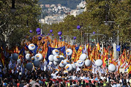 Protesters wave Spanish flags and hold balloons bearing a heart-shaped collage of the Spanish, Catalan Senyera and EU flags during a pro-unity demonstration in Barcelona on October 29, 2017. Pro-unity protesters were to gather in Catalonia's capital Barcelona, two days after lawmakers voted to split the wealthy region from Spain, plunging the country into an unprecedented political crisis. / AFP PHOTO / LLUIS GENE (Photo credit should read LLUIS GENE/AFP/Getty Images)