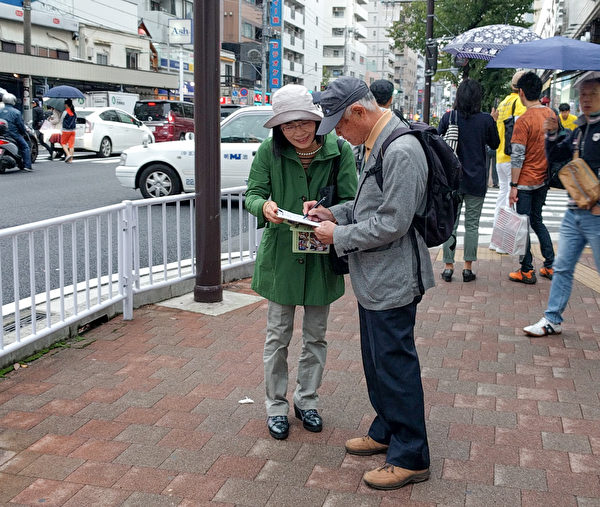 10月14日，日本部分法輪功學員在橫濱舉行了反迫害遊行活動，真相條幅吸引了很多路人觀看，中共活體摘取法輪功學員器官販賣牟利的罪行受到當地民眾的關注，很多人簽名支持法輪功學員反迫害。（盧勇／大紀元）