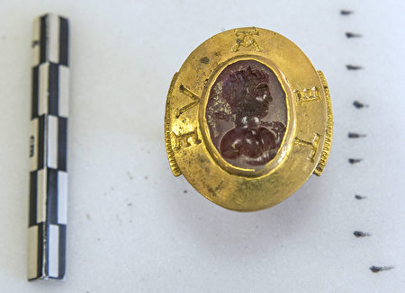 发掘出的一枚镶有镌刻着头像的红宝石的金戒指，戒指上雕刻着“Avete”。（ Credit Alexis Grattier / University Lumiere Lyon II / AFP）