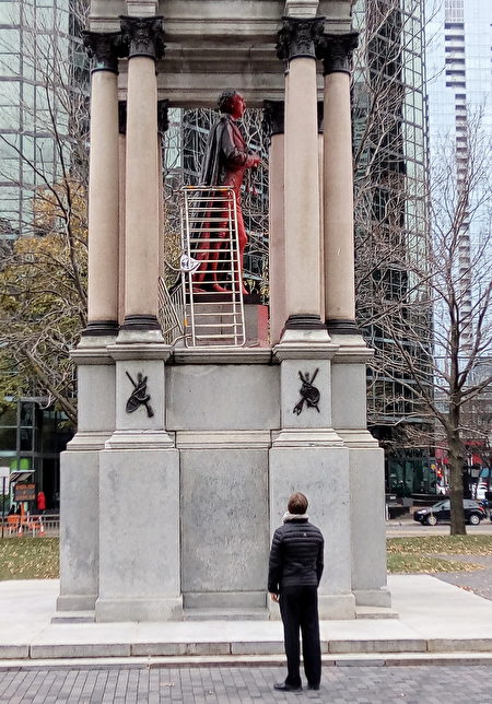 蒙特利爾市中心加拿大廣場（Place du Canada）上的加拿大首任總理麥克唐納（John A. Macdonald）紀念雕像上週末被不明人士噴上紅漆。（易柯 / 大紀元）