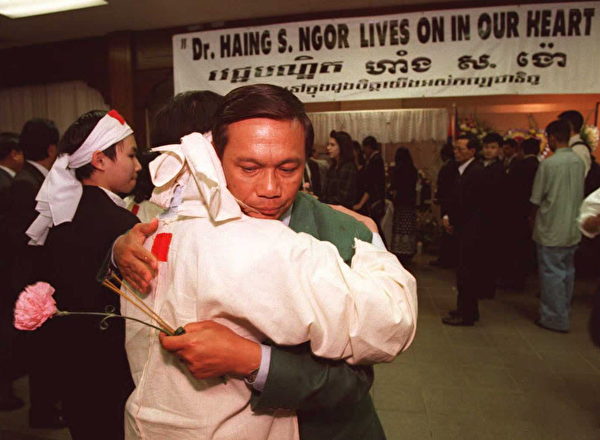 1996年2月25日，奧斯卡最佳男配角獲得者、柬埔寨裔演員Haing S. Ngor在洛杉磯遇害身亡。圖為3月8日在追思會上，Ngor曾扮演過的記者Dith Pran安慰其侄女Wathana Sarun。（KIM KULISH/AFP/Getty Images)