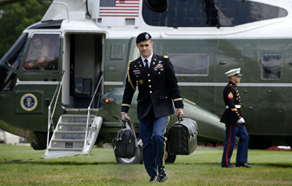 黑色公事包由轮值的军事随从携带，如图中左手所提的。(OLIVIER DOULIERY/AFP/Getty Images)