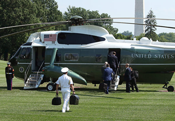 2017年8月4日，美國總統川普搭乘直昇機離開白宮，他的一名軍事隨從以右手替他提黑色公事包。（Mark Wilson/Getty Images）