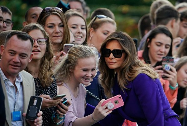 US First Lady Melania Trump poses for a photo with a guest as she and US President Donald Trump make their way to board Marine One before departing from the South Lawn of the White House on November 3, 2017 in Washington, DC, embarking on a 11-day tour of Asia. / AFP PHOTO / MANDEL NGAN (Photo credit should read MANDEL NGAN/AFP/Getty Images)