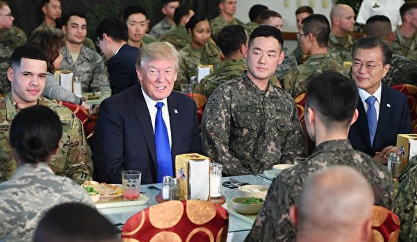 聊天環節很熱鬧，沒想到吃飯的時候，坐在兩位總統中間的小哥有些尷尬。(JIM WATSON/AFP/Getty Images)