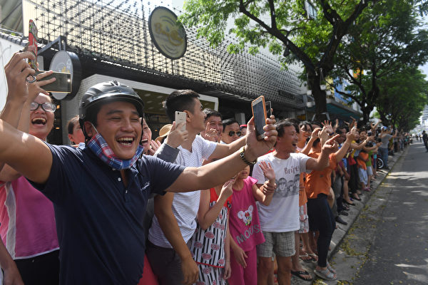 Vietnamese cheer as the convoy transporting US President Donald Trump passes by, after his arrival for the Asia-Pacific Economic Cooperation (APEC) Summit in the central Vietnamese city of Danang on November 10, 2017. World leaders and senior business figures are gathering in the Vietnamese city of Danang this week for the annual 21-member APEC summit. / AFP PHOTO / HOANG DINH Nam (Photo credit should read HOANG DINH NAM/AFP/Getty Images)
