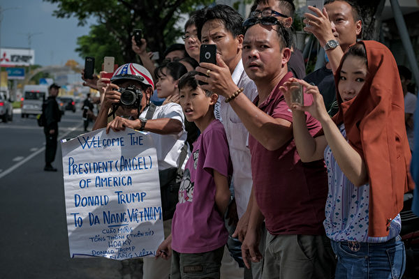 川普抵達越南時，也受到當地民眾歡迎，很多民眾在街道兩邊迎接川普，打出歡迎標語，用手機拍照。(Linh Pham/Getty Images)