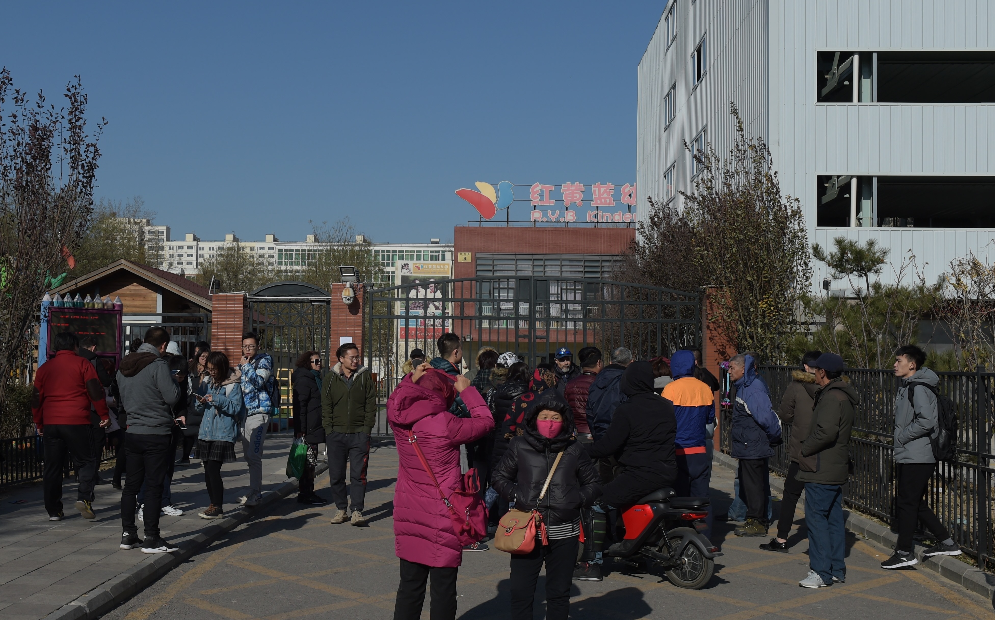 图为家长在向媒体曝光红黄蓝幼儿园虐待、猥亵孩子的真相。(Photo credit should read NICOLAS ASFOURI/AFP/Getty Images)