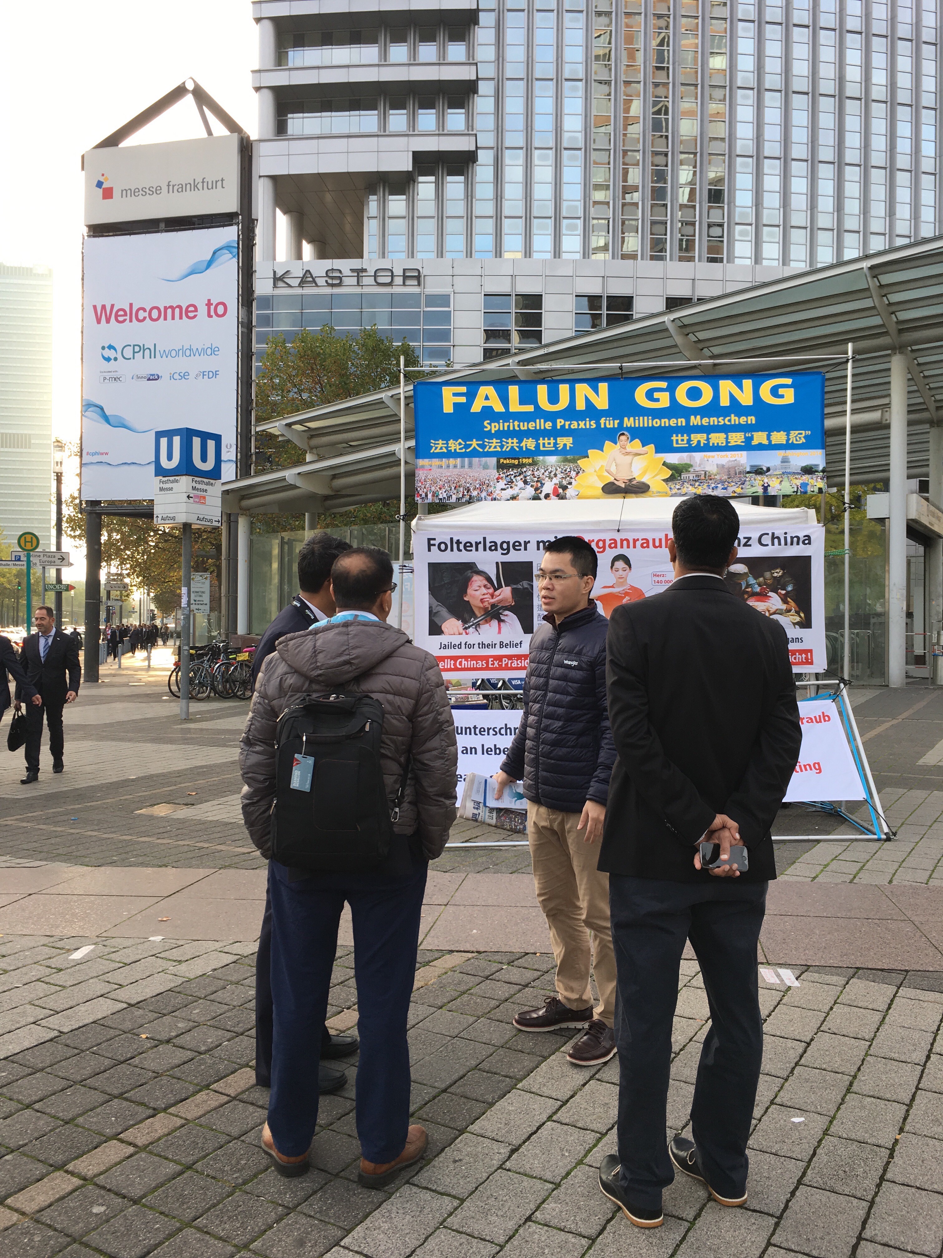 法轮功学员(右二)给展商们讲中共迫害法轮功真相。(罗琼/大纪元)
