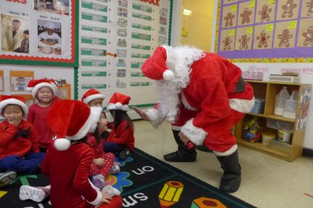 中华公所秘书谭焕瑜扮演的圣诞老人昨日到华埠儿童培护中心派发礼物，每个孩子对圣诞老人的“情绪不同”，场面热闹有趣。